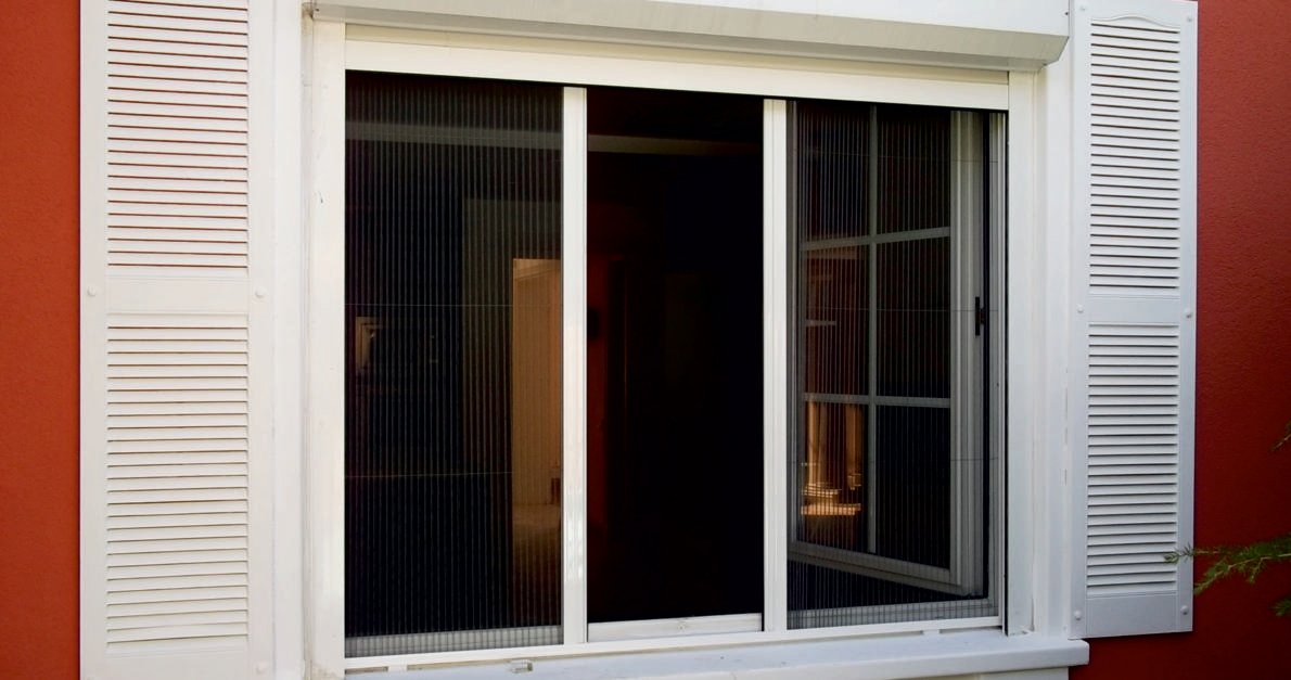 Janela com rede mosquiteira plissada recolhida a meio vão, vista do exterior